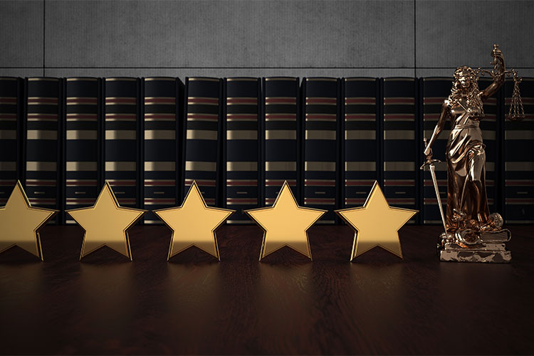 La Dama de la Justicia y cinco estrellas doradas delante de una hilera de libros jurídicos. La verdad sobre los servicios de referencia de abogados