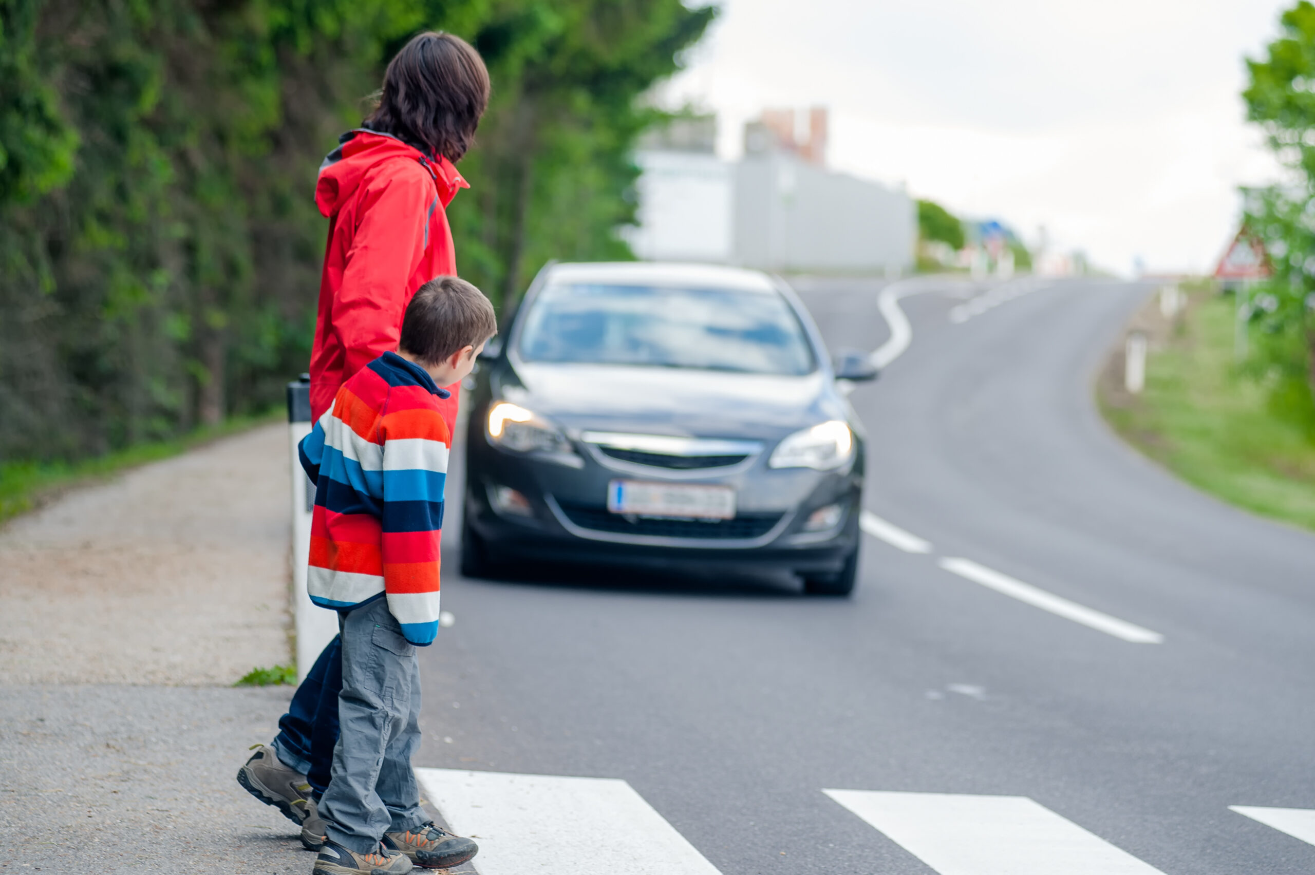 Car driving toward pedestrians crossing crosswalk.- pedestrian accident lawyer