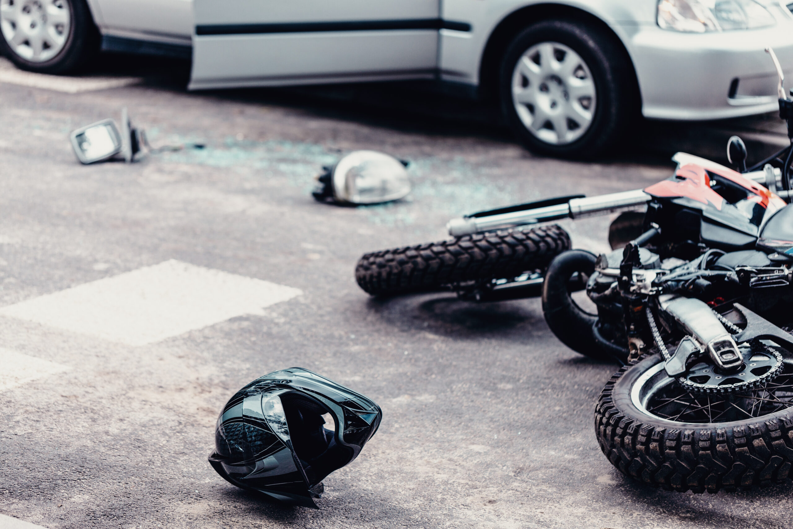 Helmet and motorcycle next to broken peaces of a car on the street after car crash. Injuries motorcycle accidents. Grand Prairie Motorcycle Accident Lawyer. Corpus Christi Motorcycle Accident Lawyers. Lubbock Motorcycle Accident Lawyer