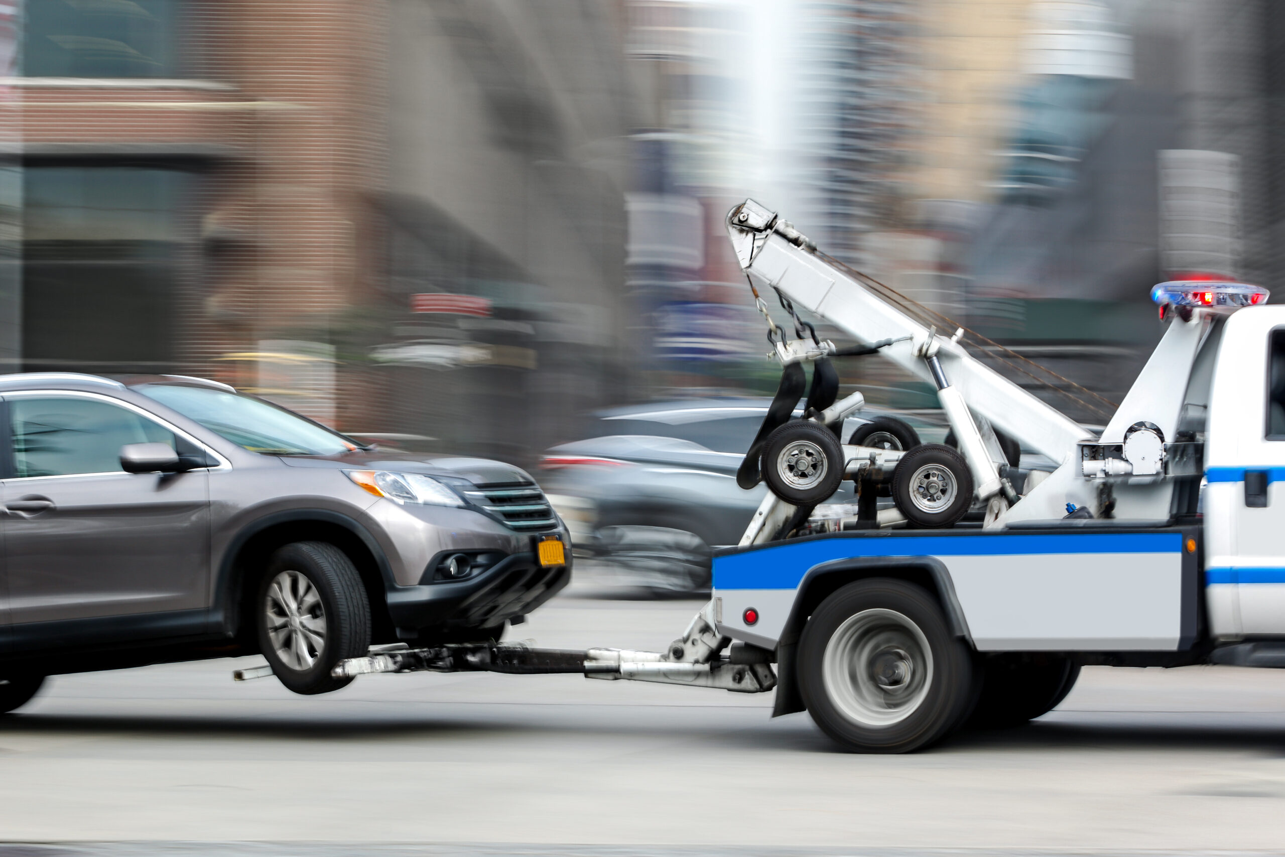 Tow truck delivers the damaged vehicle as it is towed away. Leyes estatales de remolque no autorizado de vehículos