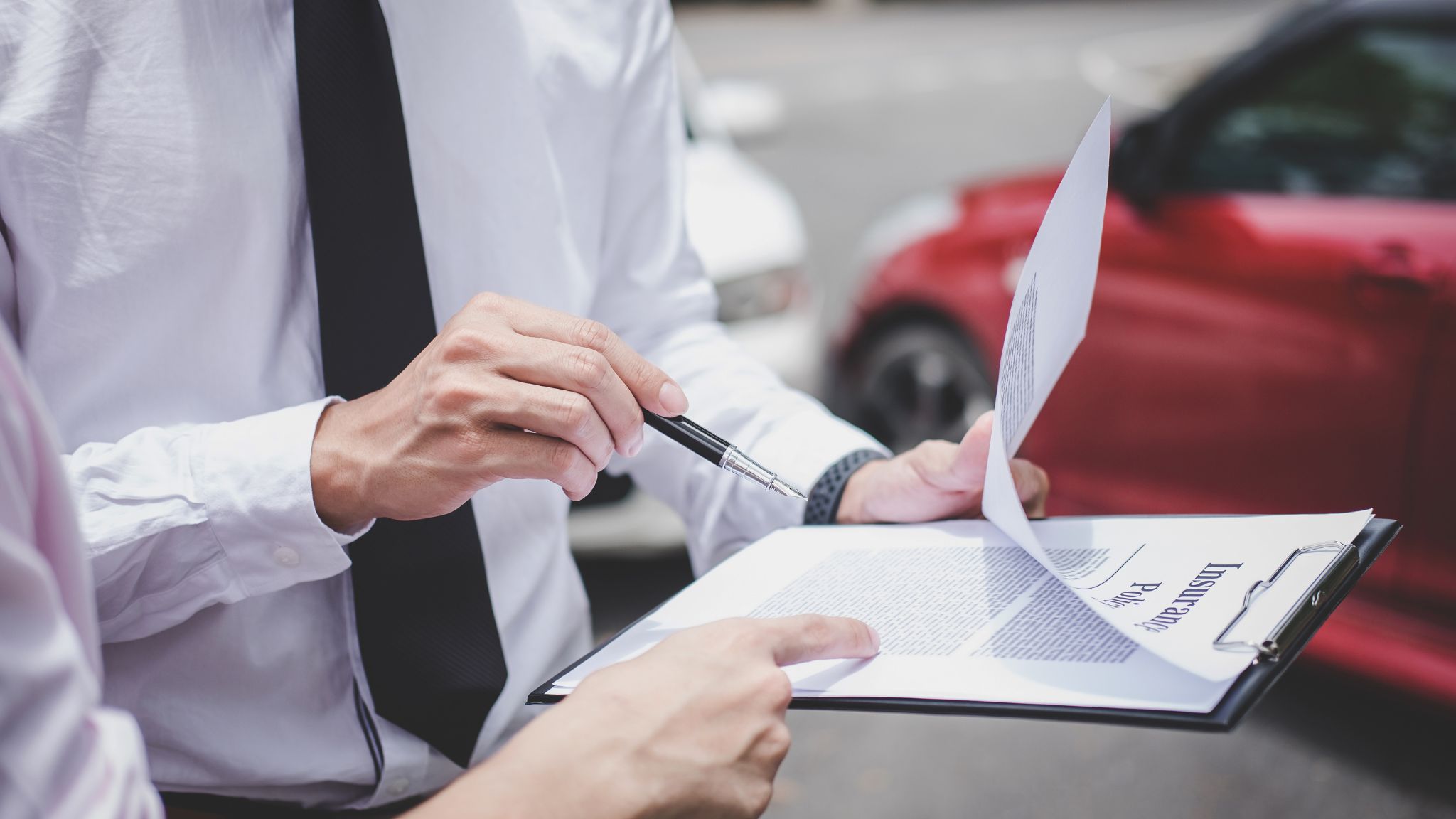 people looking at insurance claim form after an accident