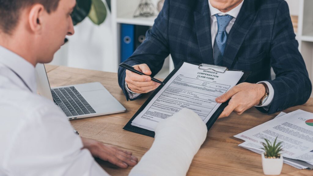 man signing damages claim form with a lawyer